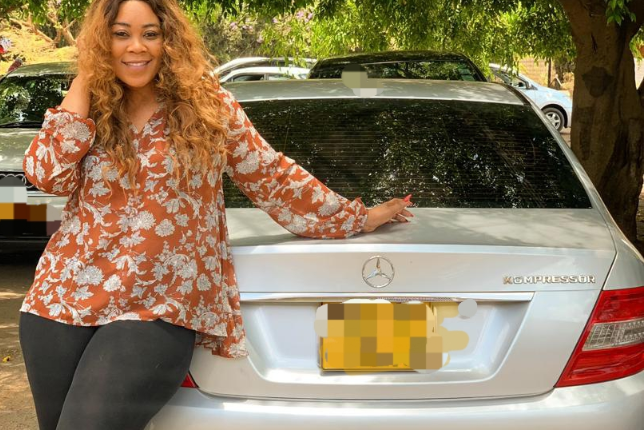 Madam Boss with new vehicle she got from Passion Java. Passion java buys madam boss a car