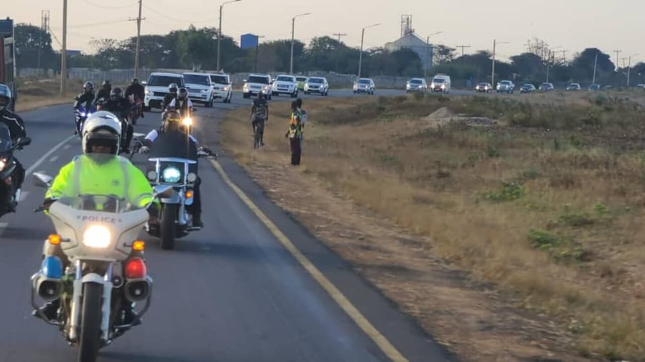 Motorcycles leading convoy of vehicles
